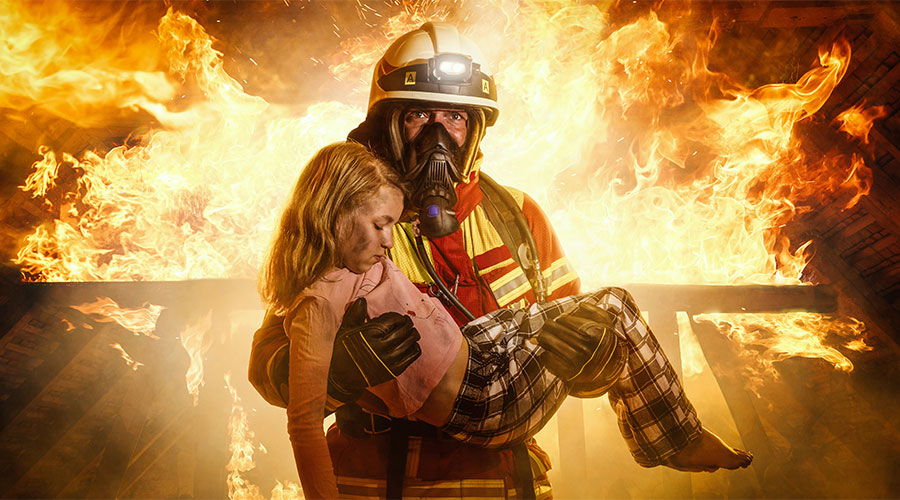 Firefighter carries child out of a fire